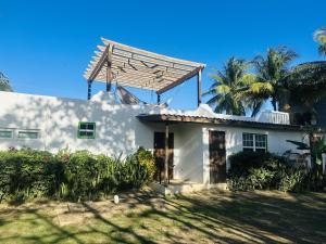 a white house with a pergola on top of it at Los Mangoes in Hopkins