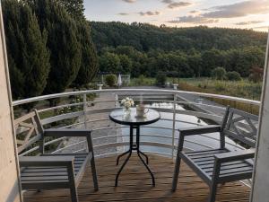 a table and two chairs on a balcony at Domaine de la Jasseix in Croze