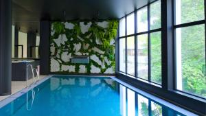 a swimming pool in a house with windows at Mariental Hotel & SPA in Szklarska Poręba