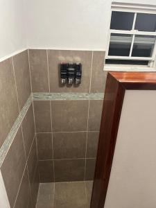 a bathroom with a shower with bottles on the wall at Los Mangoes in Hopkins
