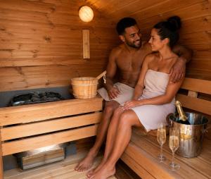 a man and a woman sitting in a sauna at 2 - Luxury Escape - Outdoor bathtub and sauna under the stars! in Pont Sticill +7 photos