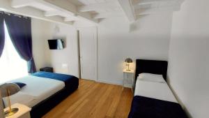 a bedroom with two beds and a desk and a window at Casa Lame in Bologna