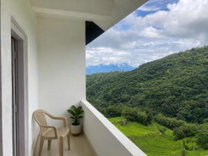 a balcony with a chair and a view of a mountain at Naga Hills Backpacker Hostel in Kohīma