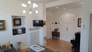 a living room with a clock on the wall and a chandelier at B&B MAST Apartment Suite in San Pellegrino Terme