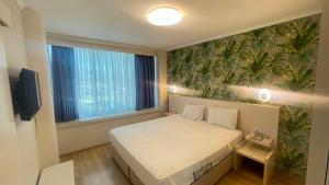 ein kleines Schlafzimmer mit einem Bett und einem großen Fenster in der Unterkunft Walkin Hotel in Konak