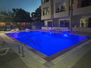 a large blue swimming pool in front of a building at Etoile DE Mer in Al ‘Ayn