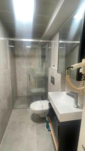 ein Badezimmer mit Dusche, Waschbecken und Toilette in der Unterkunft Walkin Hotel in Konak + 9 Fotos