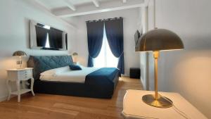 a bedroom with a bed and a lamp and a window at Casa Lame in Bologna +25 photos