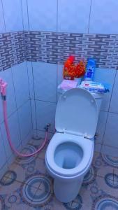 a bathroom with a white toilet with a pink hose at The Mason Hideout in Watamu