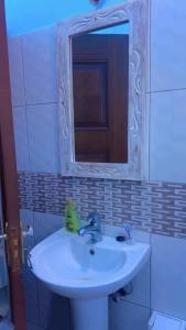 a bathroom with a white sink and a mirror at The Mason Hideout in Watamu