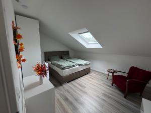 a small bedroom with a bed and a skylight at Waldzauber - Moderne Ferienwohnung im Grünen in Elpenrod