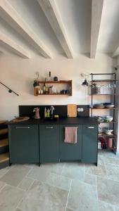 a kitchen with green cabinets and a tile floor at Casa Limone - a due passi dal lago in Castelletto di Brenzone