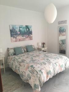 1 dormitorio con cama con edredón en Hipalis Palmera, en Sevilla
