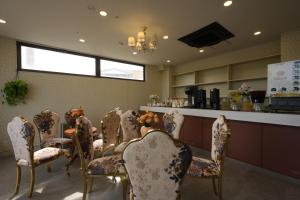 a room with a table and chairs and a bar at フルールリゾート&ホテル in Nishio