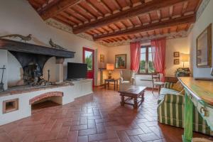a living room with a fireplace and a tv at Il Lebbio Agriresort in Montaione