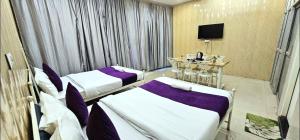 a hotel room with two beds and a television at Hotel raj inn in Lucknow