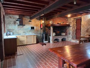 a kitchen with a fireplace and a wooden table at O Rincón de David in Cee