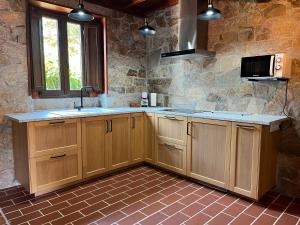 a kitchen with wooden cabinets and a sink at O Rincón de David in Cee +52 photos