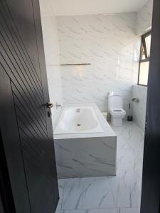a white bathroom with a sink and a toilet at Luxe Apartments in Lusaka +12 photos