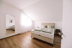 a white bedroom with a bed and a mirror at Luxoria in Livno