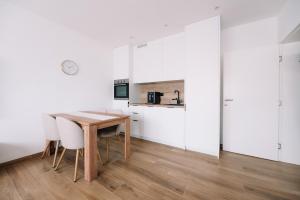 a dining room with white walls and a wooden table and chairs at Luxoria in Livno