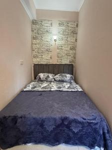 a bed in a small room with a brick wall at Kond studio in Yerevan