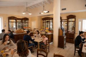 a group of people sitting at tables in a restaurant at Borgo alla Sorgente in Vallio Terme