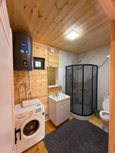 a bathroom with a washer and a sink and a toilet at Adam in Chon-Sary-Oy