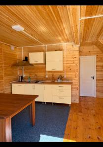 a kitchen with white cabinets and a wooden ceiling at Adam in Chon-Sary-Oy