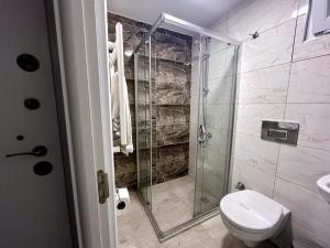 a bathroom with a toilet and a glass shower at ATAKAUM AYKA OTEl in Atakum