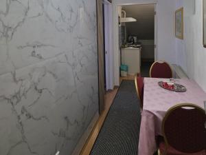a dining room with a table and a marble wall at Vila Marija Rooms in Zagreb