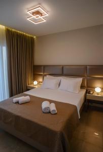 a bedroom with a bed with two towels on it at L-Suites in Kavála