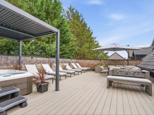 a patio with chairs and tables and an umbrella at The Penthouse - Uk52276 in Beccles