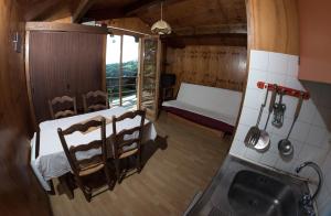 a small room with a bed and a kitchen at chalets studio du vieux frêne in Saint-Hilaire