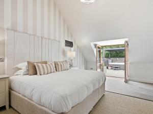 a white bedroom with a large bed and a window at The Penthouse - Uk52276 in Beccles