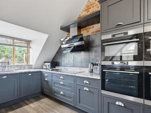 a kitchen with blue cabinets and stainless steel appliances at The Penthouse - Uk52276 in Beccles