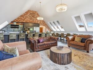 a living room with leather couches and a bar at The Penthouse - Uk52276 in Beccles +24 photos