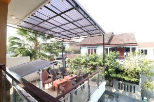 a patio with chairs and tables on a balcony at Bisma Balcony Homestay in Yogyakarta