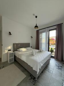 a bedroom with a large bed and a large window at La Chance Alaçatı in Alaçatı