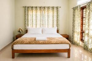 a bedroom with a bed and a window at Misty Leaf in Thekkady