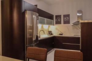 a kitchen with brown cabinets and a stainless steel refrigerator at Villa Velvet Chios in Chios +66 photos