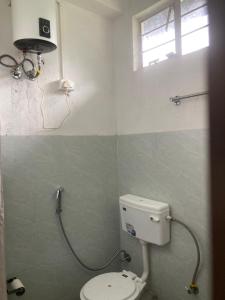 a bathroom with a white toilet and a window at Naga Hills Backpacker Hostel in Kohīma