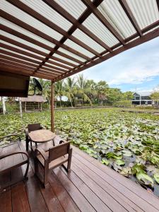 a deck with a table and a bench and lilies at TakFha Café & Resort in Ban Tha Ngam (1)