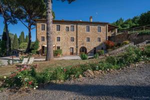 a large stone house with flowers in front of it at Il Lebbio Agriresort in Montaione