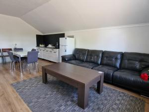 a living room with a black leather couch and a table at La Banel Hotel in Selemet