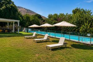a group of chairs and umbrellas next to a pool at Casa de Limon - צימרים וסוויטות בוטיק בגליל in Sede Eli‘ezer