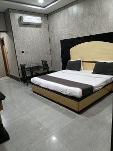 a bedroom with a large bed and a table at Hotel Rahul Palace in Nagpur