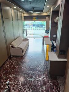 a room with a couch in a room with a floor covered in marble at Hotel Rahul Palace in Nagpur