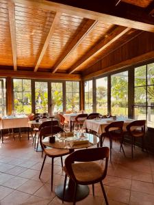 a dining room with tables and chairs and windows at Podere Picarelly in Colonnella