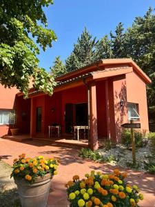 a red house with flowers in front of it at Podere Picarelly in Colonnella
